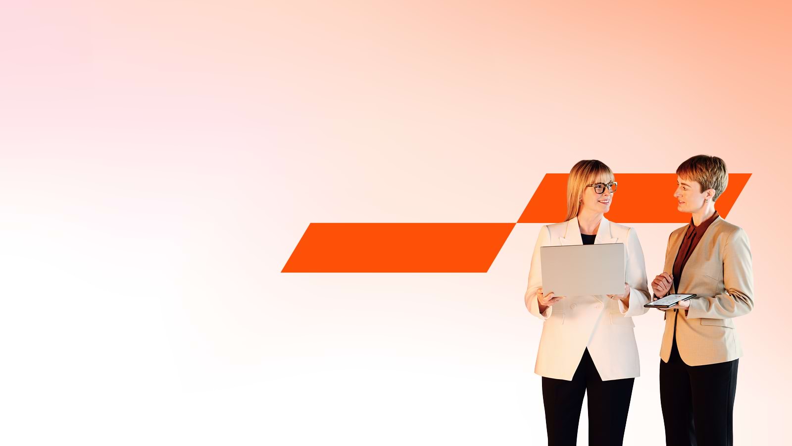 divas speciālistes sarunājas, turot rokā laptopu